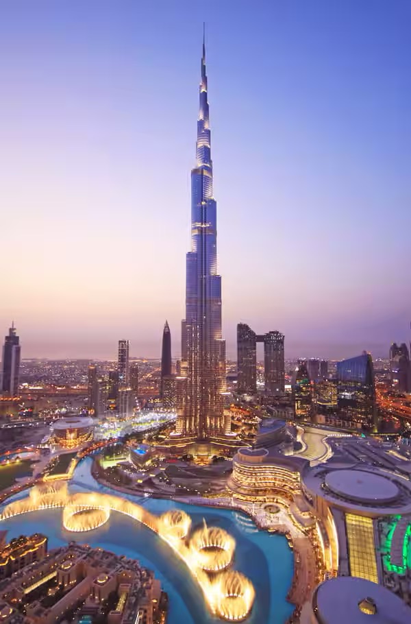 The Burj Khalifa lit up at night, reflecting its iconic design against the Dubai skyline.