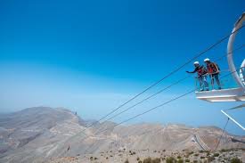 Thrill-seekers soaring on the Jebel Jais Flight, the world’s longest zipline, with stunning mountain views in Ras Al Khaimah, UAE
